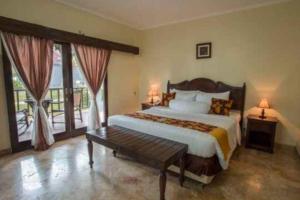 a bedroom with a large bed and a balcony at Lorin Beach Resort in Sijuk