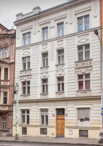 a white building with a wooden door on a street at Kent Ridge Loft in Prague