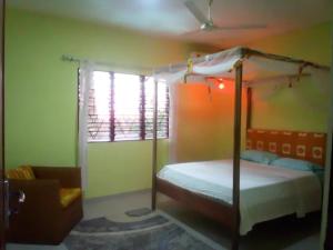 1 dormitorio con cama con dosel y ventana en Kokrobitey Apartments-GAL en Accra