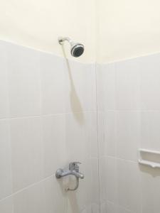 a shower with a shower head in a bathroom at Adi Pelita Sari Bali in Denpasar