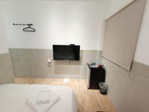 a bedroom with a bed and a flat screen tv at No 9 Hotel-九號文旅 in Tainan