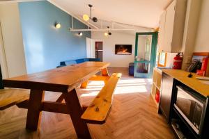a wooden table and bench in a room at The Village Green Bunkhouse in Strath Creek