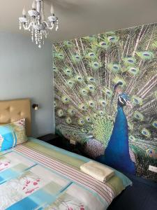 a bedroom with a peacock mural on the wall at Hotel DANIELA in Nīca