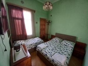 a bedroom with two beds and a window at Old House in Akhaltsikhe