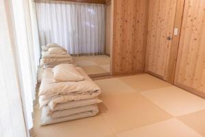 a room with a stack of blankets on the floor at 久米島 SHINMINKA Villa in Kumejima