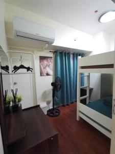 a bedroom with a bunk bed with a blue curtain at Amazing Condo @ the heart of Manila in Manila
