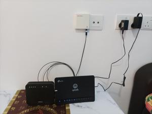 a room with a table with acomputer plugged into a wall at Ike village in Kota Samarahan