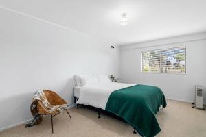 a bedroom with a bed and a chair and a window at Views over Blenheim - Blenheim Holiday Home in Blenheim