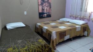 a bedroom with two beds in a room at Casa Pedacinho do Céu in Nobres
