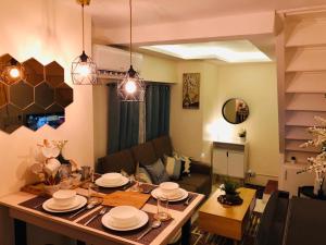マニラにあるAmazing Condo @ the heart of Manilaのリビングルーム(テーブル、皿付)