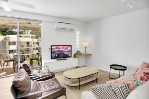 a living room with a couch and a tv at The Cove Noosa - Apartment 22 in Noosa Heads