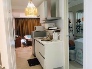 una cucina con bancone bianco e una camera con letto di Blissful escape at Azure North Pampanga a San Fernando