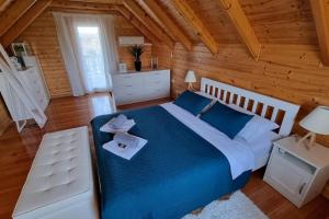 una camera con un grande letto in una baita di tronchi di 54 Green Road Varaždin a Kućan Marof