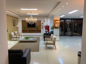 a lobby with a living room with a chandelier at Éden Hotel in Rio Verde