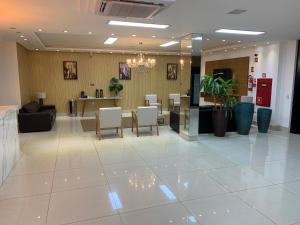 a lobby with a waiting area with chairs and a table at Éden Hotel in Rio Verde