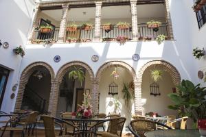 a restaurant with tables and chairs and a balcony at Hotel de Los Faroles in Córdoba