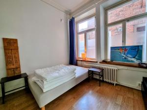 a bedroom with a bed and two windows at 4 Blocks From Stockmann in Helsinki
