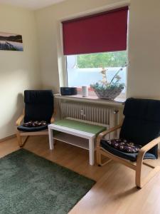 dwa krzesła i stół w pokoju z oknem w obiekcie Zentrales Apartement Bremen w Bremie