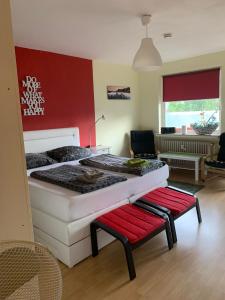 a bedroom with a large bed and a red wall at Zentrales Apartement Bremen in Bremen