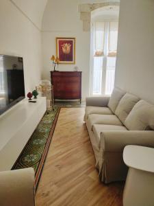 ein Wohnzimmer mit einem Sofa und einem TV in der Unterkunft COMES 5 HOME in Castellana Grotte