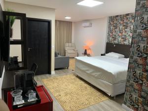 a bedroom with a bed and a living room at Éden Hotel in Rio Verde