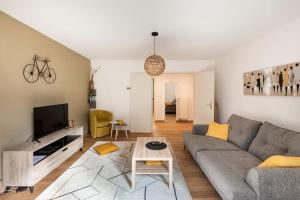 uma sala de estar com um sofá e uma mesa em Comme chez vous em Estrasburgo