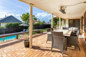 an open patio with a table and chairs on a deck at Grange Harbour View B&B in Tauranga