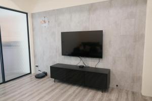a living room with a flat screen tv on a wall at Kozy Stay in Taitung City