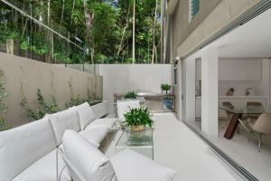 a living room with white furniture and a glass table at Little Cove Court - Apt 8 in Noosa Heads
