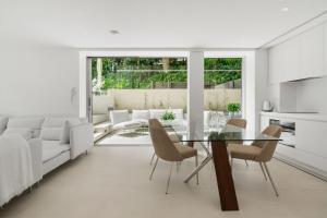 a living room with a glass table and chairs at Little Cove Court - Apt 8 in Noosa Heads +5 photos