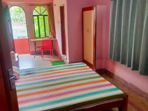 a room with a colorful rug and a table and window at Jwala Niketan Guesthouse Private rooms in Jaipur