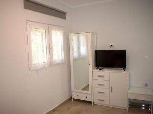 um quarto com um espelho e uma televisão numa cómoda em Astrinos Apartment, cosy and near to the beach! em Kato Daratso
