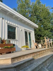 ein Haus mit einer Holzterrasse mit Stühlen darauf in der Unterkunft Stuga in Myggenäs