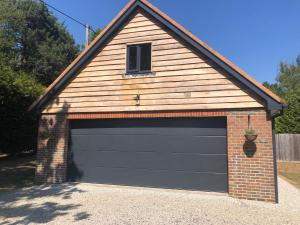 a garage with a black garage door at Oakworth Lodge - New self contained studio in Heathfield