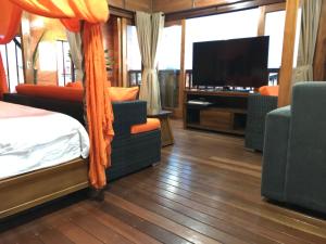 a bedroom with a bed and a flat screen tv at Seahouse Bali Indah Beach Inn in Kuta
