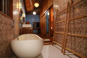 un bagno con una grande vasca in una stanza di Seahouse Bali Indah Beach Inn a Kuta