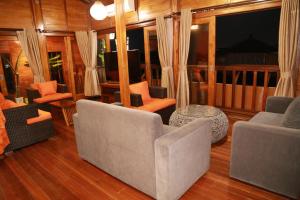a living room with couches and chairs and a television at Seahouse Bali Indah Beach Inn in Kuta