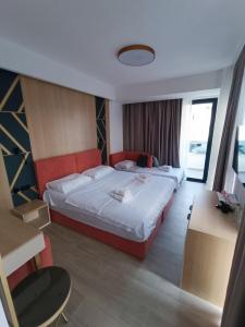 een hotelkamer met een groot bed en een bureau bij Premium - Dragovic apartments in Ulcinj