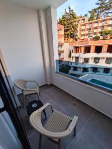 een balkon met een tafel en stoelen en een raam bij Premium - Dragovic apartments in Ulcinj