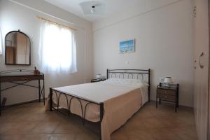 a bedroom with a bed and a dresser and a window at Veranta Me Thea in Agios Ioannis