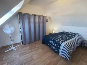 a bedroom with a bed with a black and white blanket at Le Tribord T3 étoilé avec jacuzzi in Saint-Méloir-des-Ondes