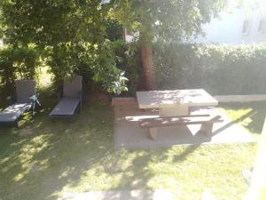 una mesa de picnic y un banco bajo un árbol en Manjina kuća, en Fužine