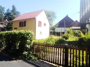 una casa blanca detrás de una valla de madera en Manjina kuća, en Fužine
