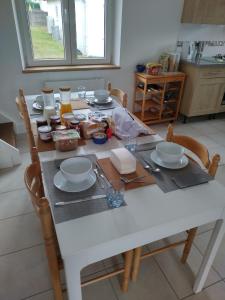 een witte tafel met borden en borden erop bij Verte Vallée in Callac