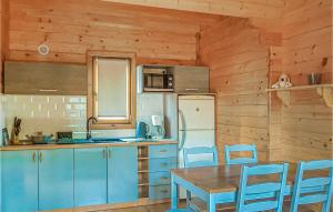 a kitchen with blue cabinets and a table and chairs at Cozy Home In Mscice With Kitchen in Mścice