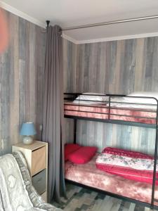 a bedroom with two bunk beds with red pillows at STUDIO la TOUSSUIRE EN SAVOIE in La Toussuire