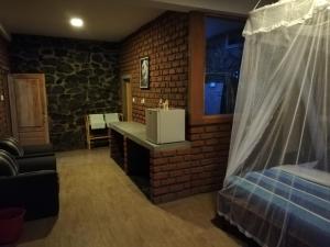 Habitación con cama y pared de ladrillo en Ayubo Ella - Bed & Breakfast, en Ella