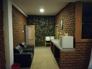 um quarto com uma parede de tijolos, um balcão e cadeiras em Ayubo Ella - Bed & Breakfast em Ella