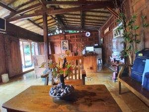 a living room with a table with a vase on it at Dem Ayem Heritage Guest House in Yogyakarta