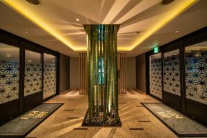 un vestíbulo con una columna en el medio de una habitación en ホテル継kei男塾ホテルグループ, en Himeji
